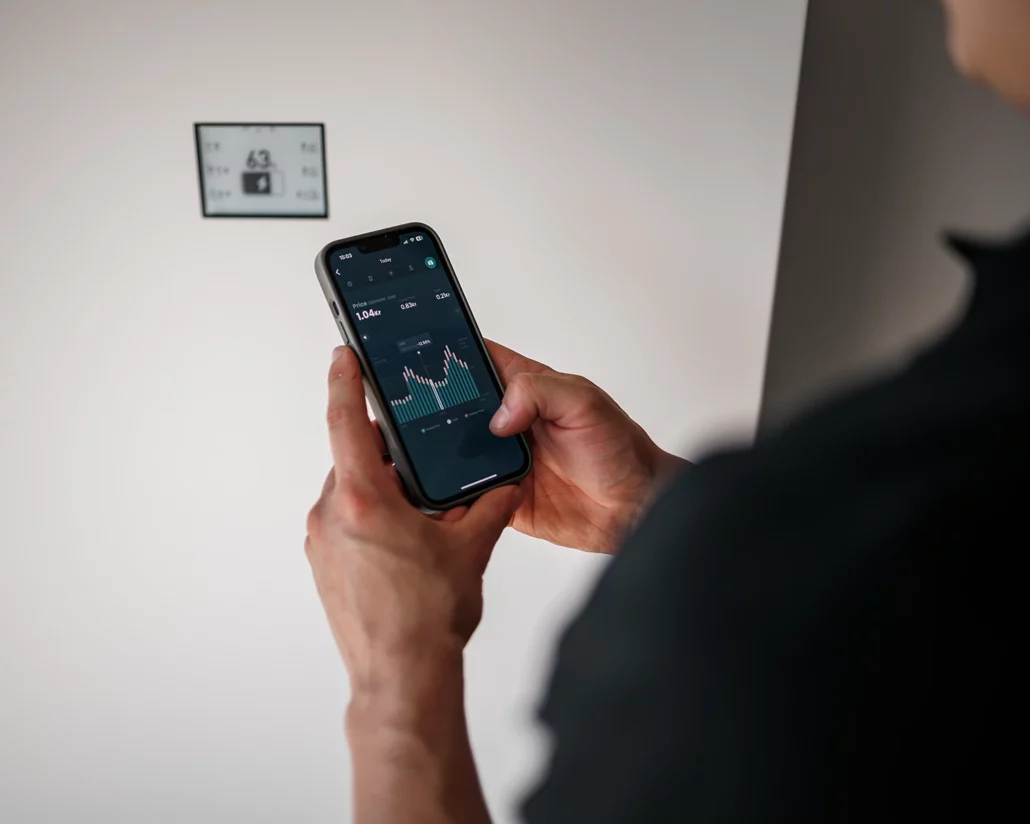 Smart hem installation av elektriker i Stockholm, med app som visar energidata och kostnad kopplat till elmätare på väggen.